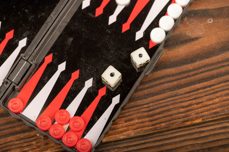 Backgammon board with chips and dice on a wooden table, close-up, selective focus