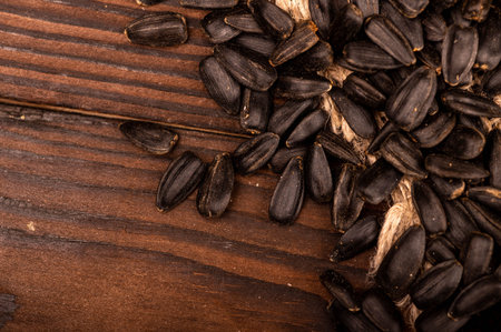 Fried black sunflower seeds scattered on the table, close-up, selective focus