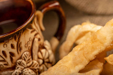 Fried bread sticks with salt and a ceramic mug, close-up, selective focusの写真素材
