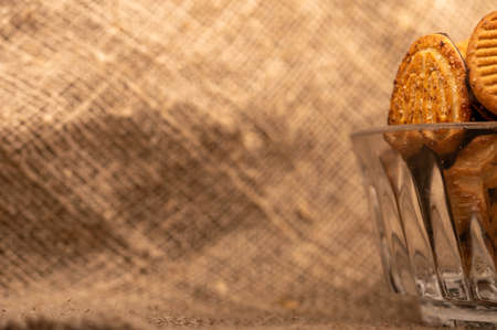 Curly cookies covered with chocolate icing in a glass vase, close-up, selective focuの写真素材
