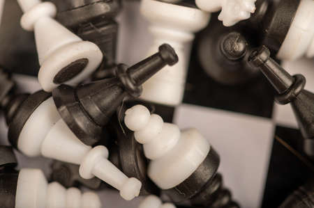 A chess board and black and white chess pieces on a wooden table, close-up, selective focusの写真素材
