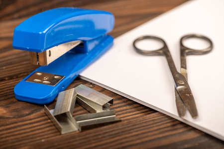 Office stapler, stapler staples and white paper on the table, close-up, selective focusの写真素材