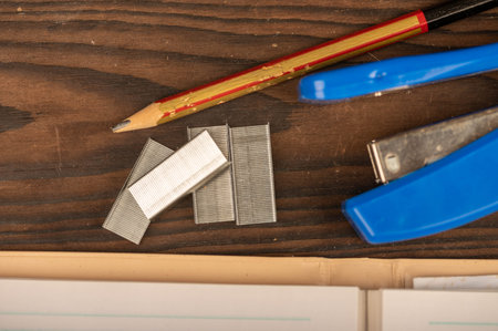 Office stapler, stapler staples and white paper on the table, close-up, selective focus
