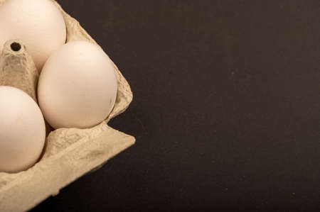 White chicken eggs in a tray made of white cardboard, close-up selective focusの写真素材