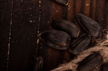 Fried black sunflower seeds scattered on the table, close-up, selective focusの写真素材