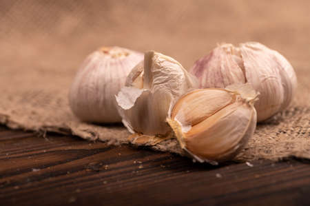 Heads of young garlic on a table covered with burlap, close-up, selective focusの写真素材