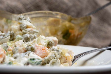 Russian traditional Olivier salad with vegetables and meat. Winter salad for New Year and Christmas. close up, selective focusの写真素材