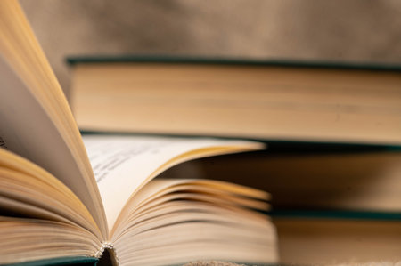 A stack of books and an open book on the table. Close-up, selective focus.