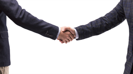 Two business men in suits shake handsの写真素材