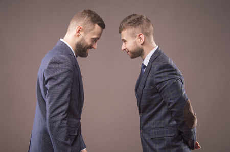 Two men in suits butting each other and smilingの写真素材