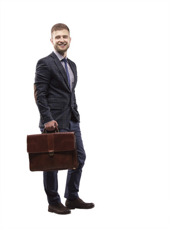 Young man smiling in a suit with a briefcase in his handsの写真素材