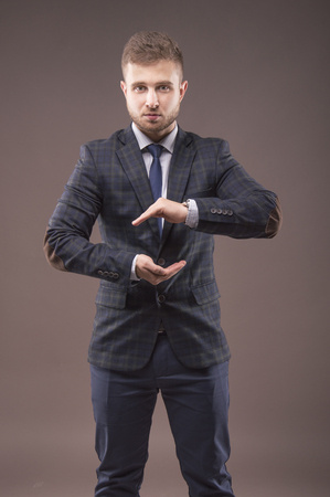 Man in a suit made a shape of a ball from his hands and looking in cameraの写真素材