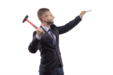 Young man beats hammer on the chisel with a smileの写真素材