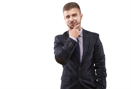 Young man in a suit stroking his beard with a smileの写真素材