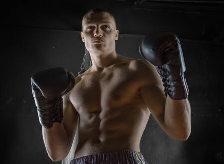 The professional boxer stands in the fighting stance and looks menacingly at the enemyの写真素材