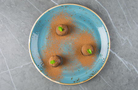Three elegant cakes in the form of balls decorated with a mint leafの写真素材
