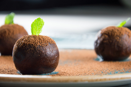 Three elegant cakes in the form of balls decorated with a mint leafの写真素材