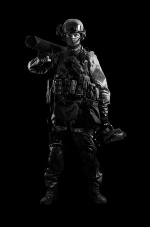 The soldier of the special unit stands in military uniform with a ram on his shoulder and a device...