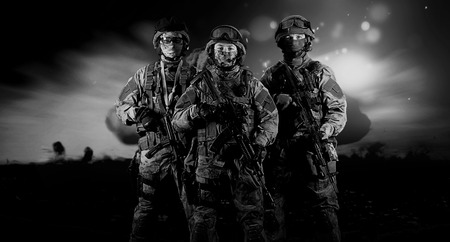 Three soldiers in uniform with a weapon in their hands are looking menacingly. Mixed mediaの写真素材