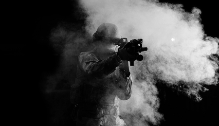 American soldier in combat ammunition with weapon in the hands of equipped laser sights is in battle order. Mixed mediaの写真素材