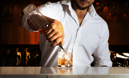 Professional at the bar prepares mixed drinks for his guests. Mixed mediaの写真素材