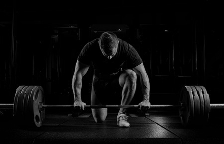 Professional athlete bent over the barbell and is preparing to lift a very heavy weight. Front viewの写真素材
