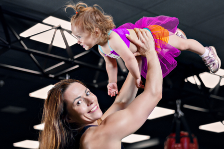Mom throws her daughter up in the gym. Mixed mediaの写真素材
