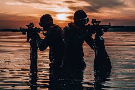 Team of fighters of a special unit move on water to complete the task. The concept of instability, military operations, the cold war. Mixed mediaの写真素材