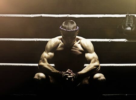 World champion in Thai boxing is sitting in the ring and getting ready for the next fight. The concept of sport, healthy lifestyle, sports nutrition. Mixed mediaの写真素材