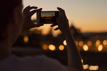 Hands of a girl holding a phone. She takes pictures of Santa Maria Del Fiore. The concept of tourism, recreation, happiness. Mixed mediaの写真素材