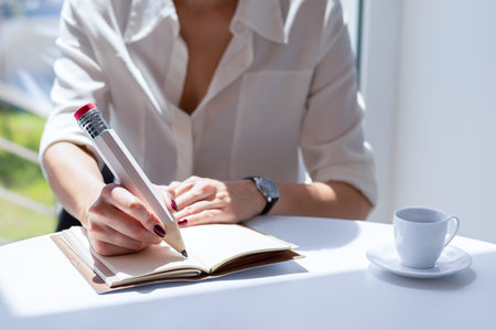 The girl writes in a notebook with a large pencil. Concept of job interview, business, success....