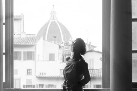 Charming woman stands in the Palazzo Vecchio against the background of the basilica. Tourism and travel concept. Mixed mediaの写真素材