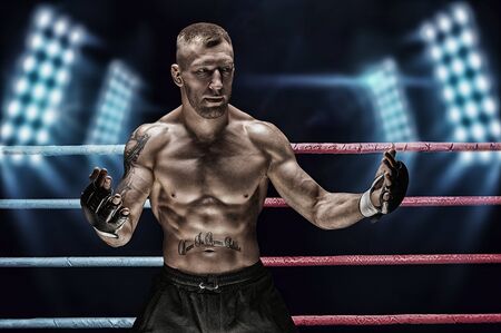Mixed martial artist posing in the ring against spotlights. Concept of mma, ufc, thai boxing, classic boxing. Mixed mediaの写真素材