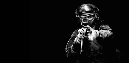 Portrait of a special forces soldier who is aiming at a collimator sight of a machine gun. The concept of special military units. Computer games. Mixed mediaの写真素材