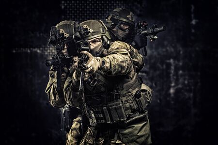 American soldiers in combat ammunition with weapons in the hands of equipped laser sights are in battle order. Mixed mediaの写真素材