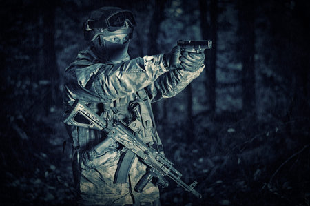 Portrait of a soldier in the forest. He shoots a pistol. Border Protection Concept. Mixed media