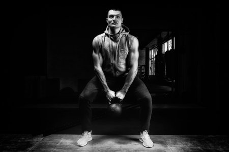 Athlete squat with kettlebell in the gym. Crossfit, weightlifting concept. Mixed mediaの写真素材