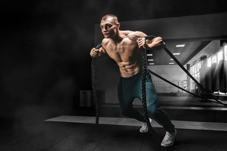Portrait of an athlete who pulls the ropes. View from below. The concept of sport and healthy...