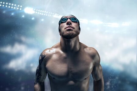Portrait of a swimmer on the background of a sports arena. The concept of swimming and water games. Front view. Mixed mediaの写真素材