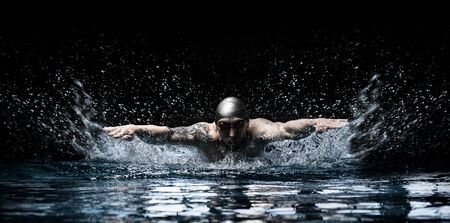 Man is swimming breaststroke. Water sports concept. Mixed mediaの写真素材