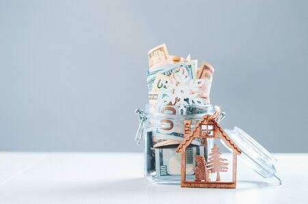 Glass piggy bank full of money. Christmas and New Year concept. Gift expenses. Mixed mediaの写真素材