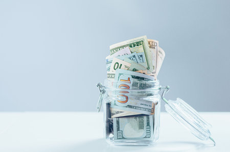 Glass jar full of money. Crisis Savings Concept. Mixed media