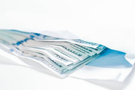 Pack of hundred-dollar bills lies in an envelope. The concept of bribery and corruption. Mixed mediaの写真素材