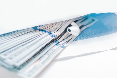 Pack of hundred-dollar bills along with a bug lie in an envelope. The concept of bribery and corruption. Mixed mediaの写真素材