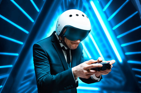 Portrait of a man in a suit and helmet of a pilot with a joystick in his hands. He enthusiastically plays a computer game. Game space. Game concept. Mixed mediaの写真素材