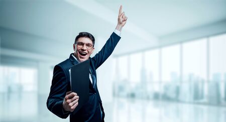 Man with a tablet in his hand screams with joy in the office. The concept of achieving success in business. Mixed mediaの写真素材