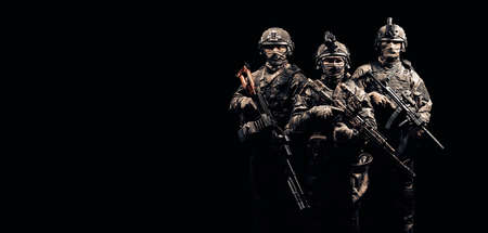 Three soldiers in uniform with a weapon in their hands are looking menacingly. Mixed mediaの写真素材