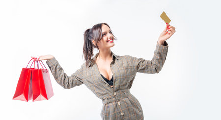 Charming brunette posing in the studio with red packages and a bank card. Gift concept. Shopping...