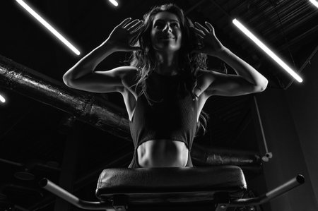 Charming brunette doing hyperextension in the gym. Press pumping. Fitness and bodybuilding concept. Mixed mediaの写真素材