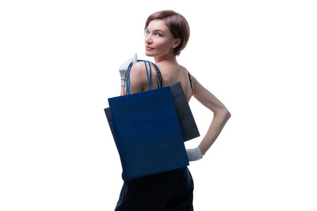 Beautiful young woman in white gloves threw a black craft bag over her shoulder. Shopaholics concept. Spenting. Gifts for the holidays. Black Friday. Shopping centers. Mixed mediaの写真素材